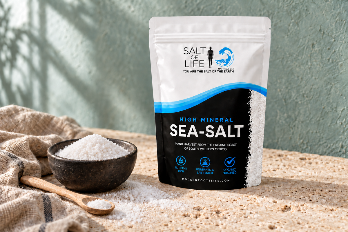Salt of Life sea salt pouch beside a bowl and wooden spoon of white sea salt on a stone counter.